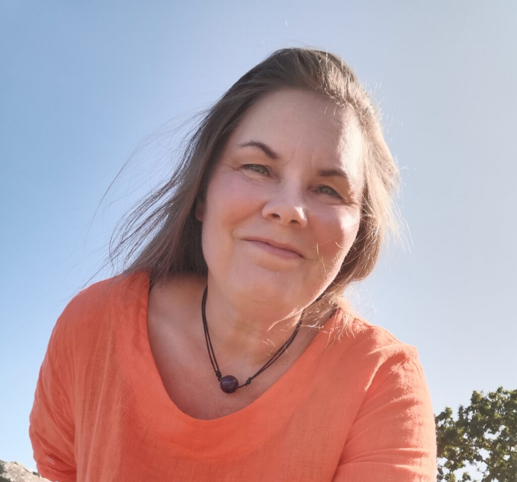 Viola Ehlers steht vor ihrer Praxis unter blauem Himmel. Sie bietet Hypnose bei Hamburg in Ammersbek