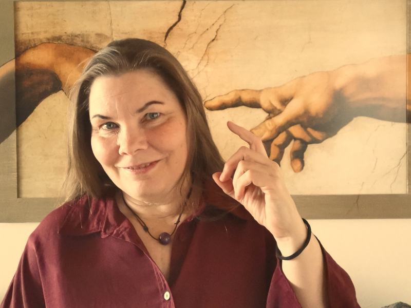 Viola Ehlers steht vor dem Kunstwerk "Die Erschaffung Adams" und hält die Hand nach oben. Sie bietet Stressmanagement bei Hamburg an.