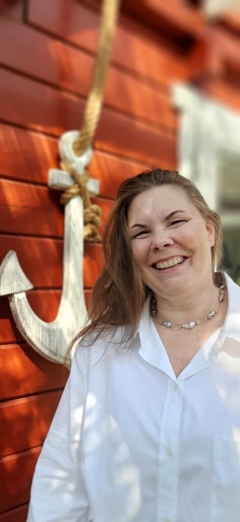 Viola Ehlers steht an ihrer Praxistür vor einem Anker. Sie bietet Ängste lösen bei Ahrensburg an.