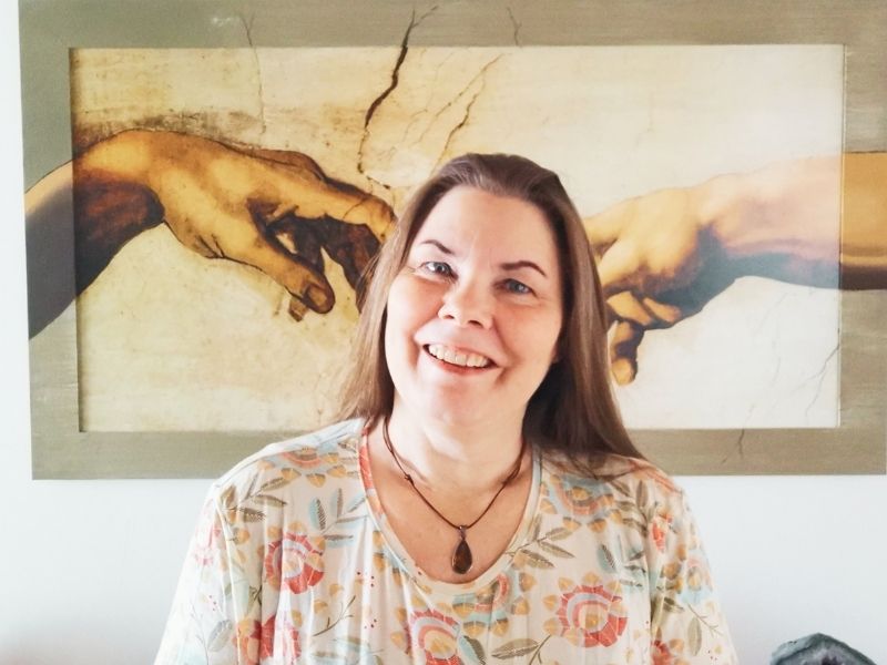 Viola Ehlers steht vor einem Kunstwerk "Die Erschaffung Adams" von Michelangelo. Sie bietet EMDR in Ahrensburg an.